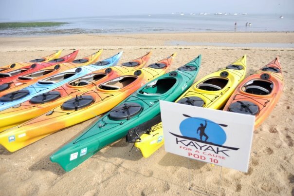 A line of kayaks on a beach for Kayak for a Cause.